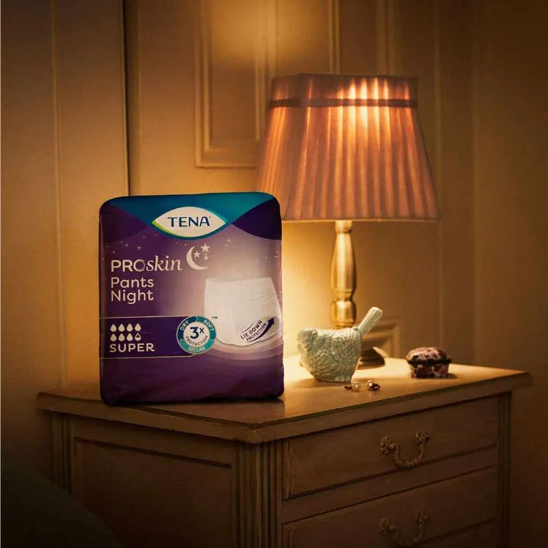 TENA Pants Night Super Verpackung steht auf einer Komode
